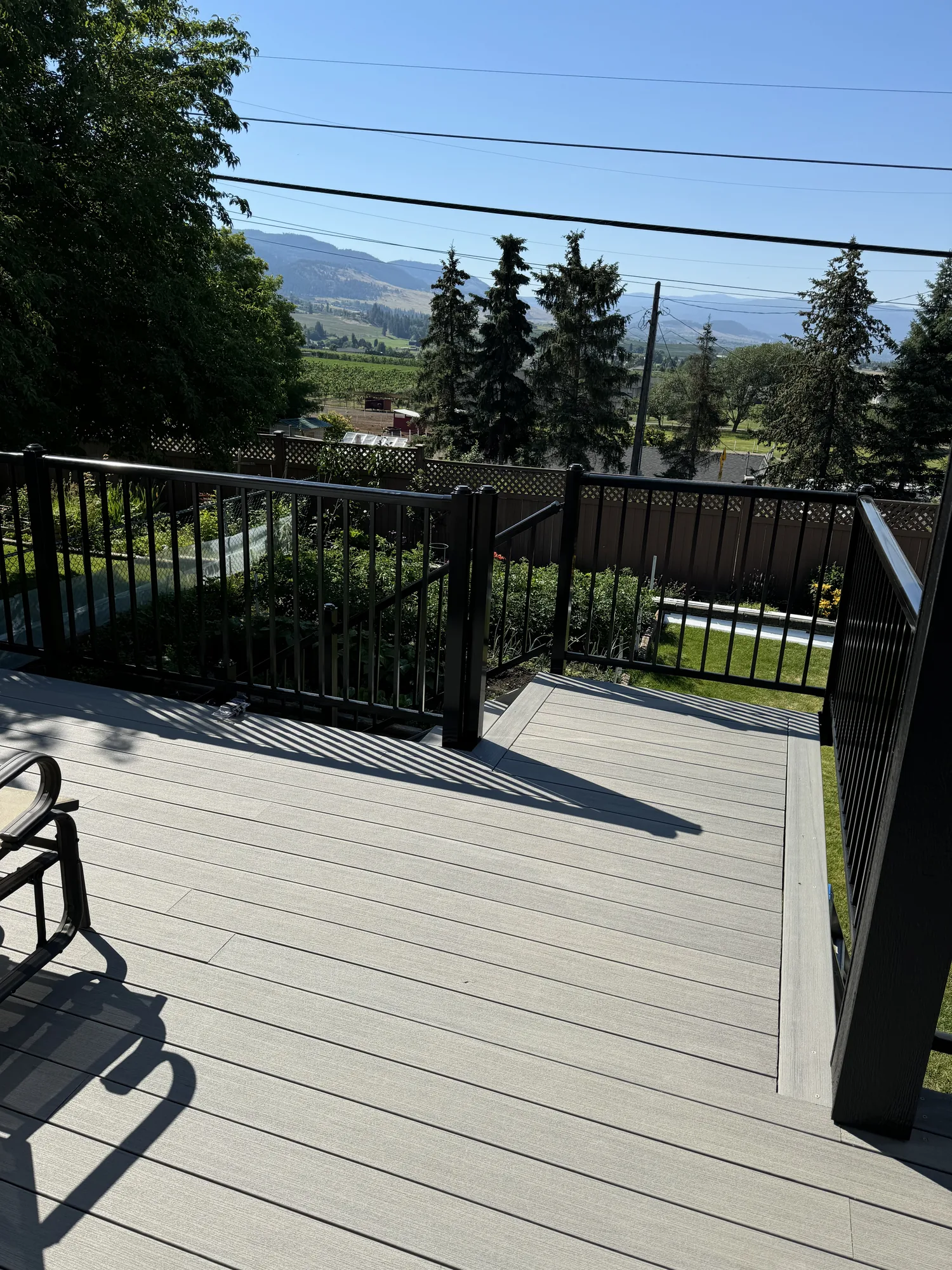 Finished grey composite deck with black railing and open view